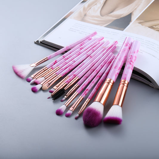 A collection of 15 high-quality makeup brushes with soft pink handles and intricate marble patterns, perfect for creating flawless makeup looks.